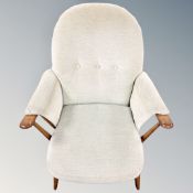 A 20th century Ercol elm and beech armchair with green cushions in an antique finish