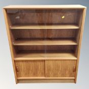 A mid 20th century teak sliding glass door bookcase