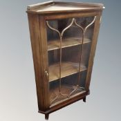 A late 20th century corner display cabinet on raised legs