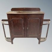 A 20th century beaded oak double door cabinet fitted with stick stands