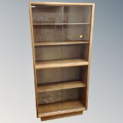 A mid 20th century teak double sliding glass door cabinet