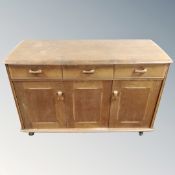 A mid century Ercol double door sideboard fitted with three drawers