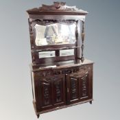 A Victorian carved breakfront mirror back sideboard, fitted with cupboards and drawers beneath.
