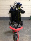 Two child's part golf club sets in bags, together with a folding golf trolley.