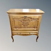 A Continental oak fall front cabinet fitted with a drawer on cabriole legs.