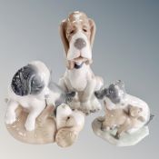 A Nao figure of a seated hound together with two further Nao figure groups, playful puppies.