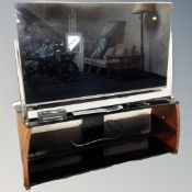 A Panasonic TX50DX802B LED TV on contemporary three tier stand, together with sound bar speaker,