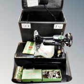 A Singer 222k electric sewing machine with accessories in case