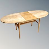 A mid century teak extending dining table together with three Ercol chairs