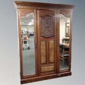 A Victorian walnut and mahogany triple mirrored door wardrobe with matching sunk centre dressing