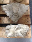 A concrete figure of a cherub together with further cherub wall pocket