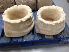 A pair of concrete planters in the form of sacks