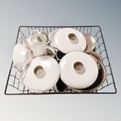 A basket containing a quantity of vintage Poole tea and dinnerware.