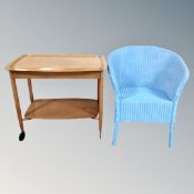 A 20th century teak two tier trolley with lift up top and a basket chair