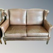 A two seater brown leather settee and matching armchair