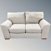 A contemporary two seater settee in grey fabric