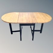 A contemporary pine extending table on black painted base