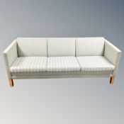 A cotemporary three seater settee in light green and cream fabric