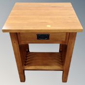 A contemporary oak lamp table fitted a drawer