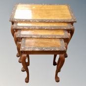 A nest of carved walnut tables