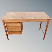 A mid century teak desk fitted with four drawers