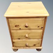 A pine three drawer bedside chest