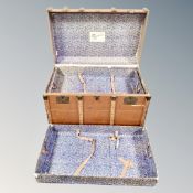 An early 20th century bentwood shipping trunk with lift out trays bearing labels