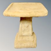 A concrete rose bird bath