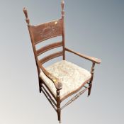 A carved oak panel backed Arts and Crafts armchair