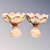 A pair of concrete garden planters on stands