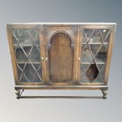 A late Victorian oak double door glazed bookcase on raised legs (Af)