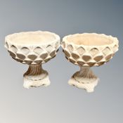 A pair of concrete garden planters on stands