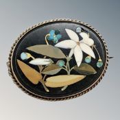 An oval pietra dura brooch in gold frame