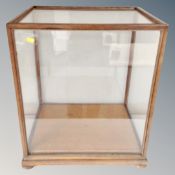 An Edwardian glazed oak shop counter display cabinet on bun feet,