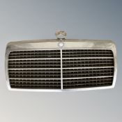 A Mercedes Benz car grill with badge.