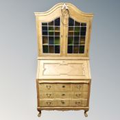 A Danish blonde oak double leaded glass door bureau bookcase,