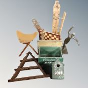 Two vintage wooden crates containing coat hooks, chessboard, a leather tripod stool,