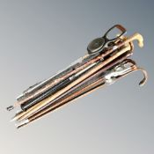 A bundle of assorted vintage walking and shooting sticks.