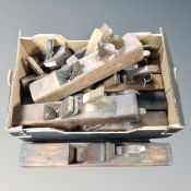A box containing assorted vintage woodworking planes.