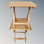 A pair of folding teak lattice garden occasional tables.