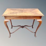 A late Victorian mahogany and walnut occasional table with under stretcher on paw feet