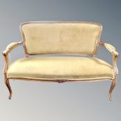 A carved beech framed salon settee in golden dralon