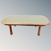 A late Victorian oval mahogany dining table inset a green leather panel