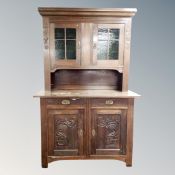 An early 20th century Scandinavian carved oak glazed door dresser