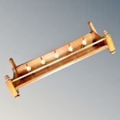 A mahogany and brass five hook coat rack