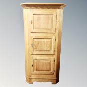 A 20th century Danish blond oak triple door corner cabinet