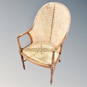 An Edwardian beech and bergere tub armchair