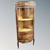 A Louis XV style corner display cabinet with ormolu mounts on raised legs