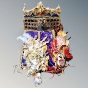 Two decorative Venetian style face masks with decorations and a double door cabinet with mini