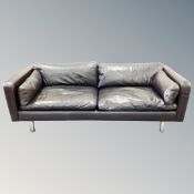 An Italian black leather low settee on metal legs